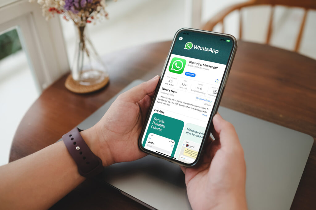 Whatsapp-Chat-End-to-End-Verschlüsselung, Hände halten Smartphone mit geöffneter WhatsApp-Anwendung
