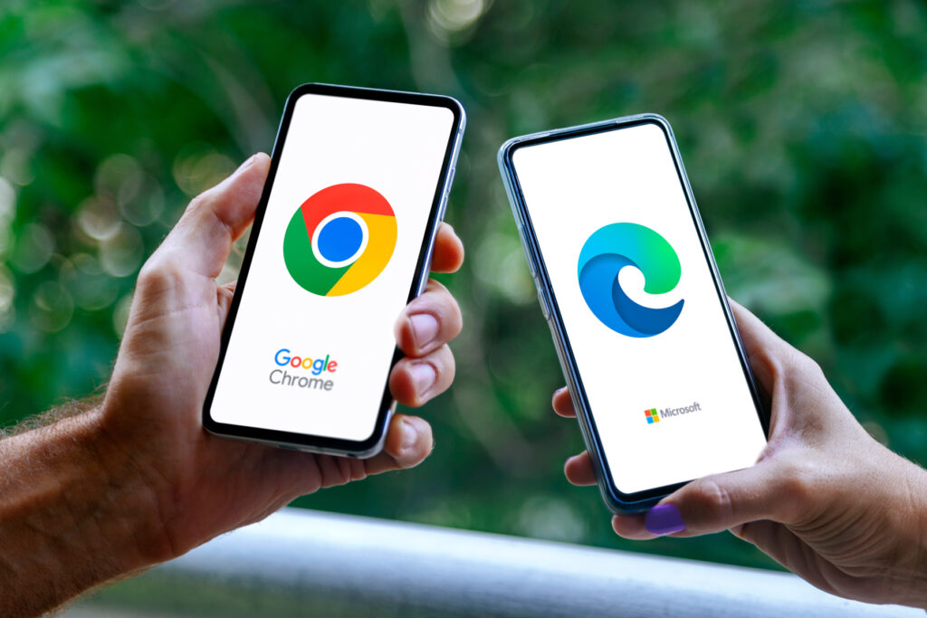Hände von zwei Personen mit Mobiltelefonen, die den Chrome-Browser auf der einen und Microsoft Edge auf der anderen Seite zeigen. Rosario, Argentinien - 8. März 2025.