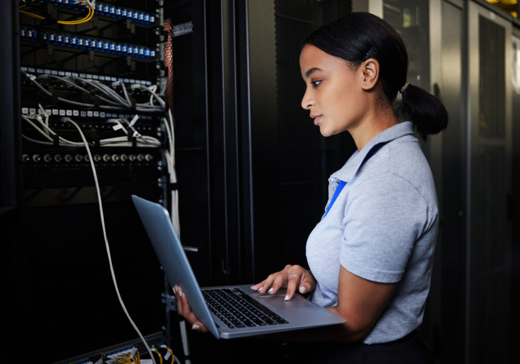 Ingenieur, Laptop-Datenbank und Frau im Serverraum für Software-Update oder Wartung in der Nacht. Cybersecurity Coder, Cloud Computing und weiblicher Programmierer mit Computer für die Vernetzung im Rechenzentrum.