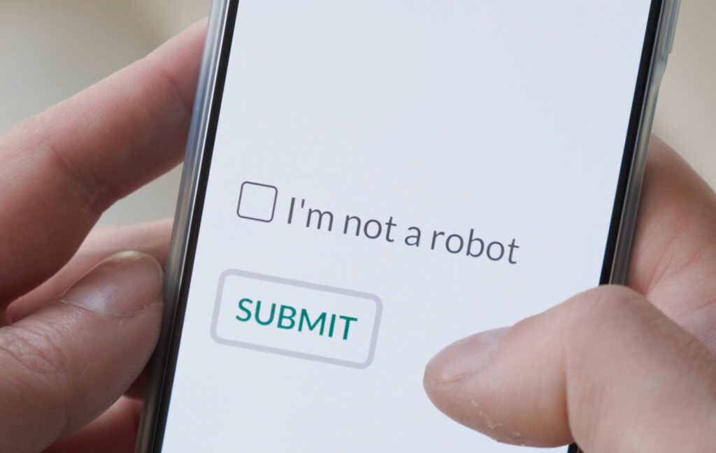 I m not a robot checkbox on phone screen with Submit button. Concept, technology, human check, verification, hands, close up.