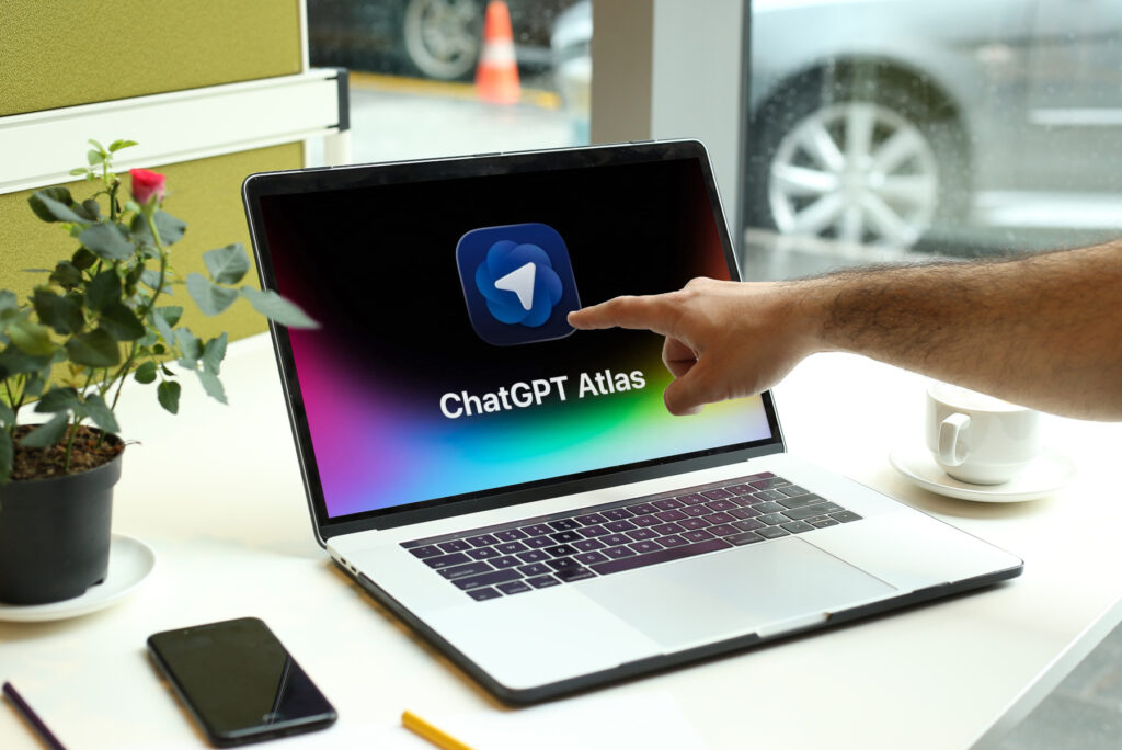 User interacting with chatgpt atlas application on laptop